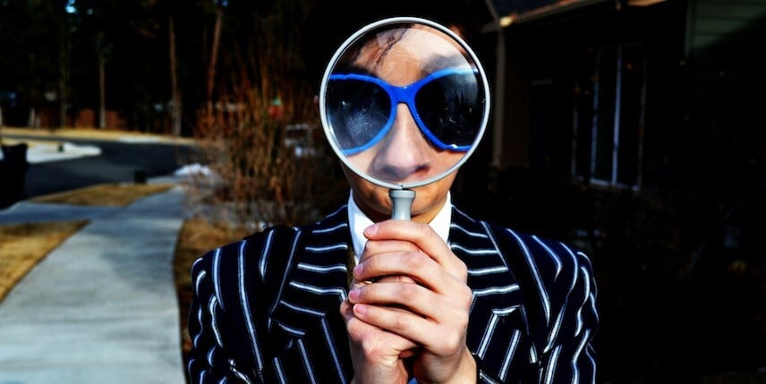 Man In Suit Searching With Magnifing Glass