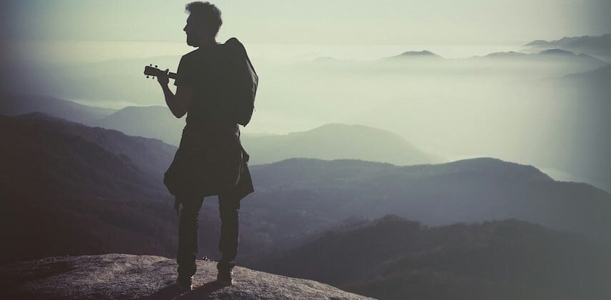Man Looking Over Mist Covered Mountains