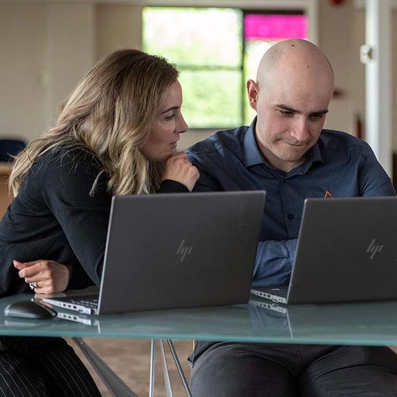 Alto workers sitting at desk with laptops