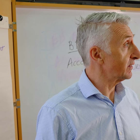Man standing in front of whiteboard in classroom
