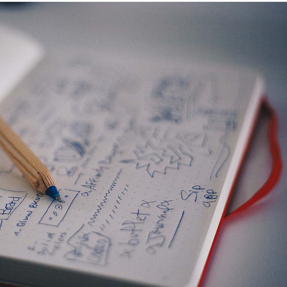 writing notes in pen on a notepad