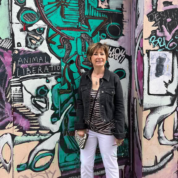 Claire Cormack standing in front of a graffiti wall