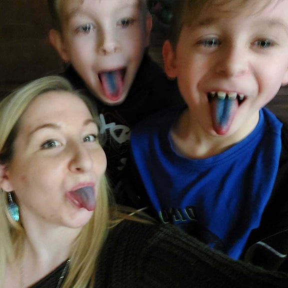 Islamarie with her kids sticking out their blue tongues