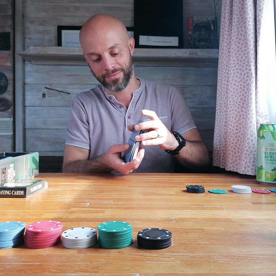Rob sitting at table shuffling playing cards
