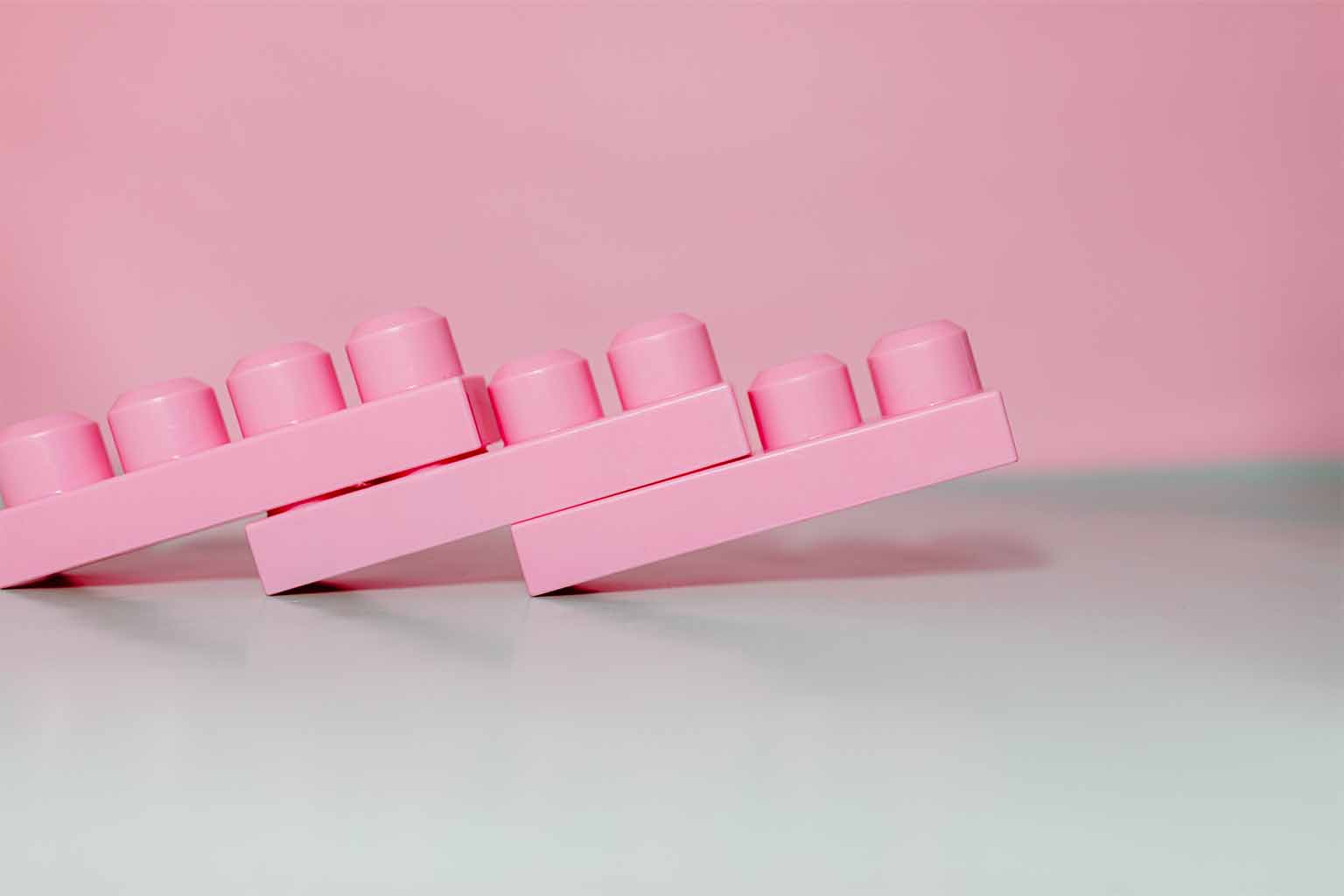 Three pink Lego-like shapes assembled together