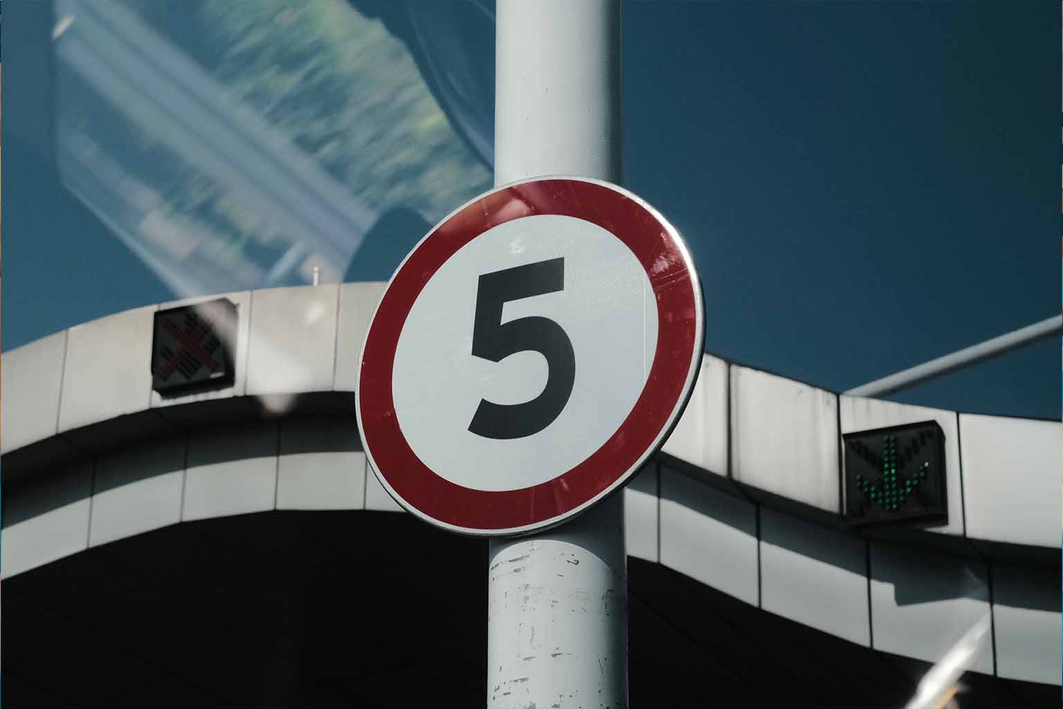 A speed limit circular road sign with the number 5