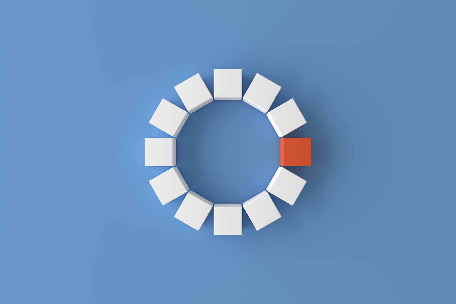 12 cubes positioned to form the shape of a loading spinner against a blue background. One of the cube is red while the others are white.