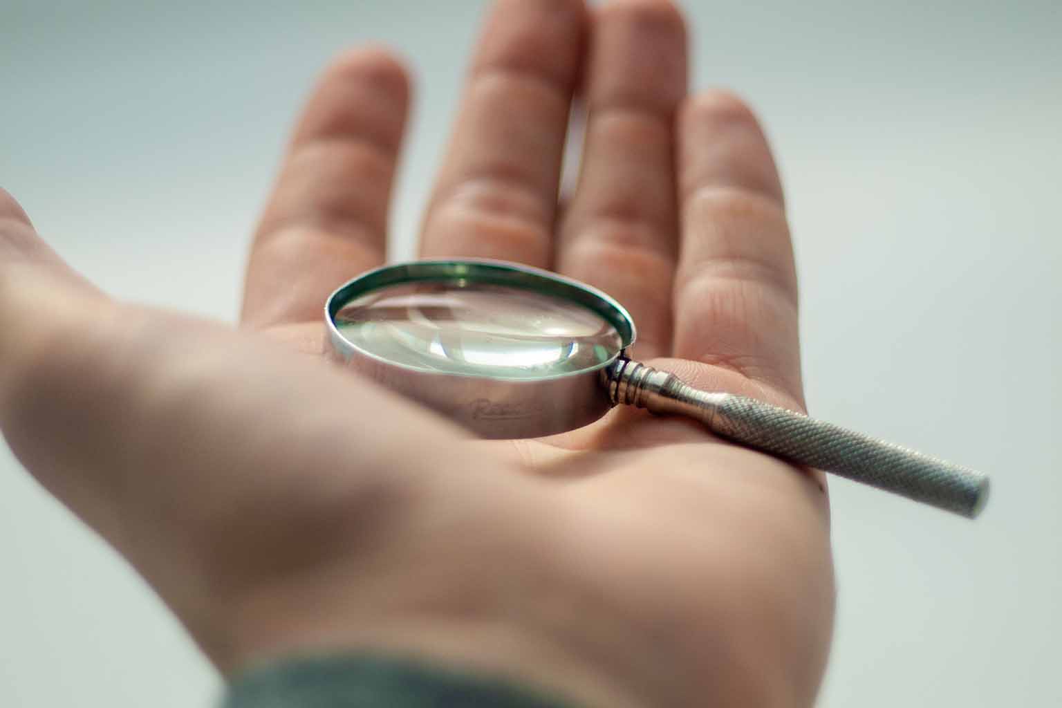 A small magnifying glass cradled in the palm of an upturned hand