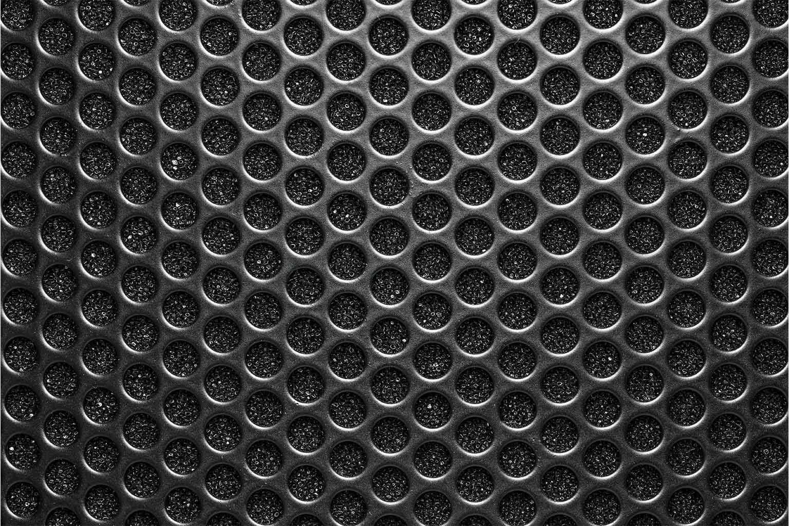 Detailed abstract pattern of a metallic speaker grille showing geometric texture