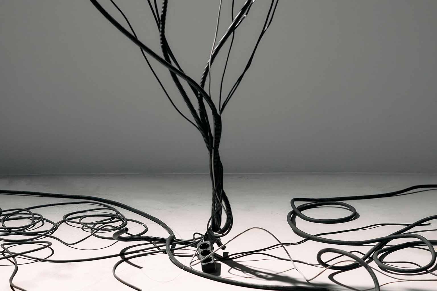 A tangle of black cables against a white and grey background