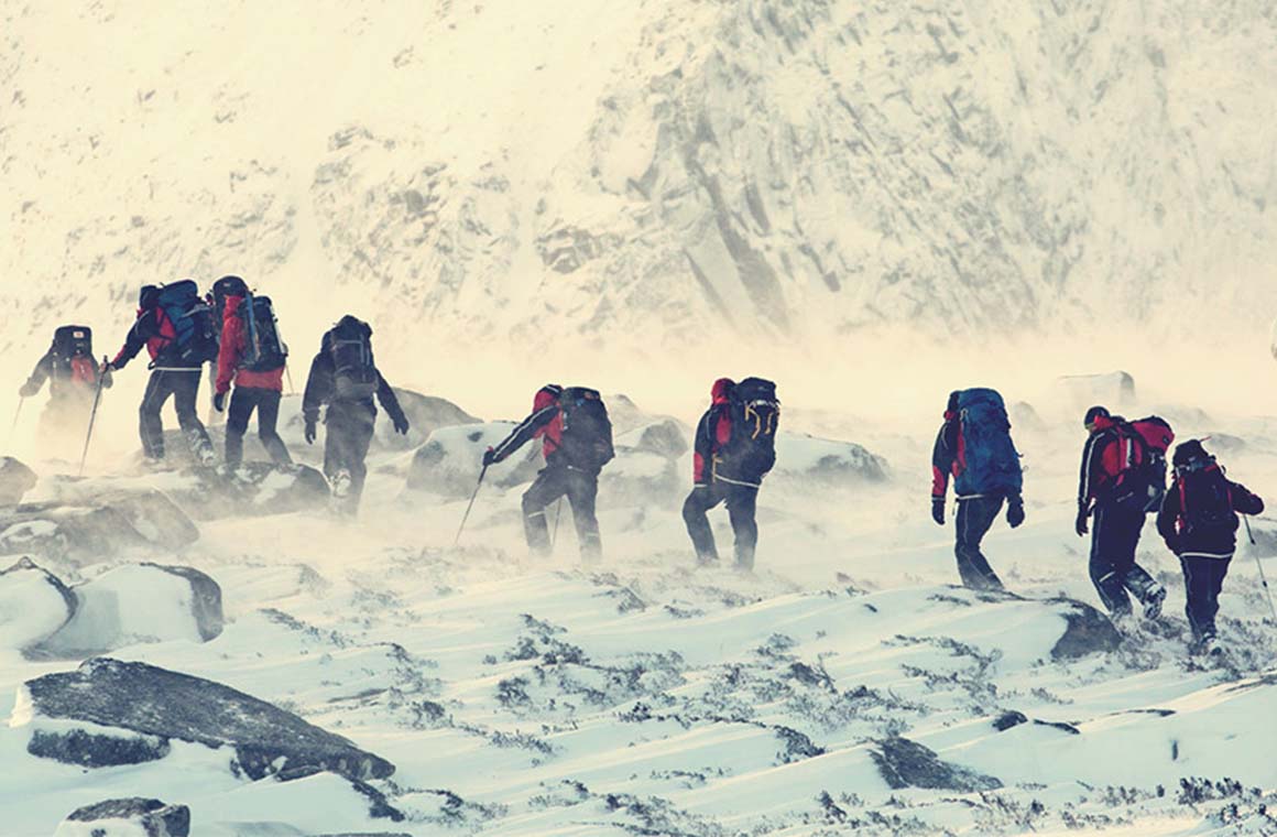 People climbing up a snowy mountain