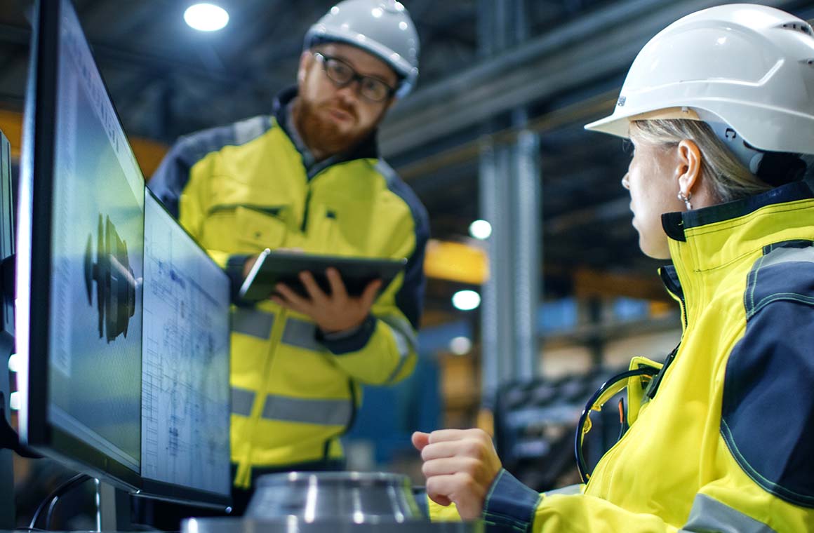 two workers with safety gear on in workhop