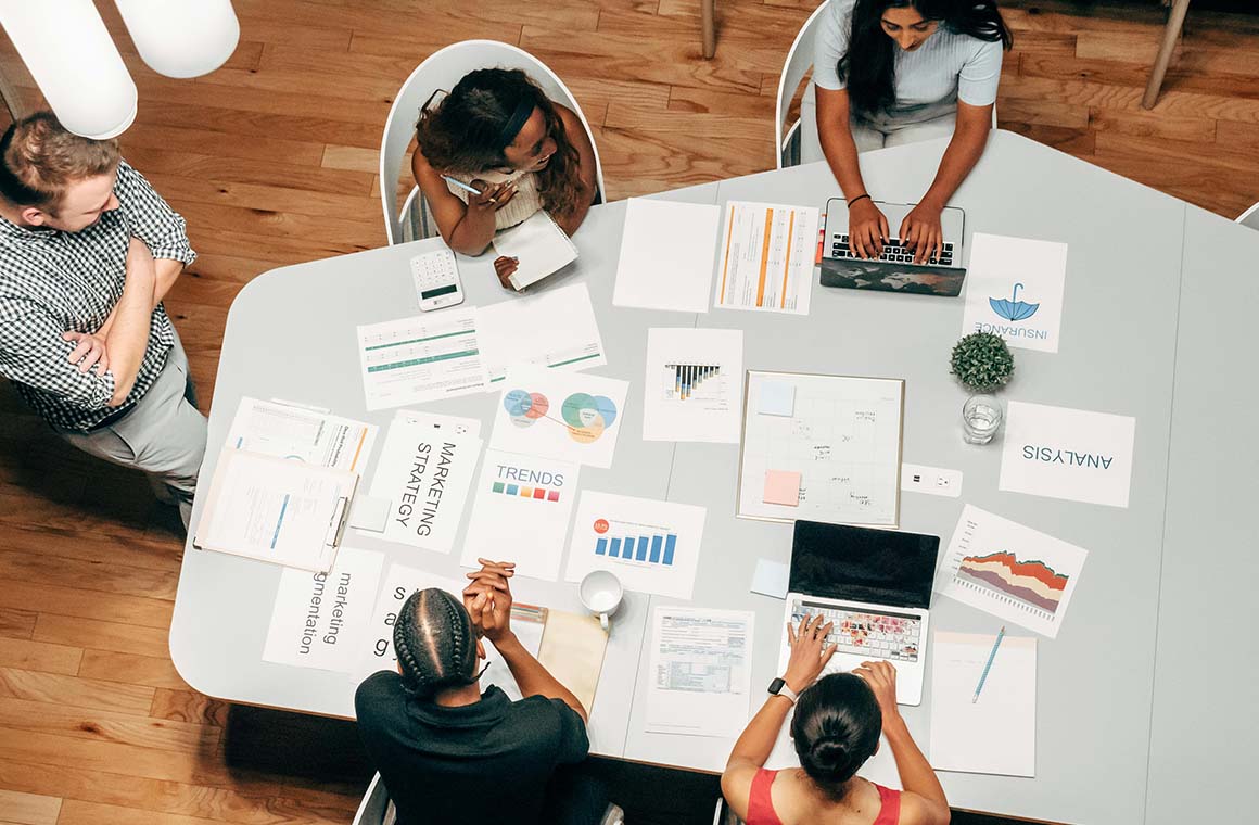 Various people round a desk working 