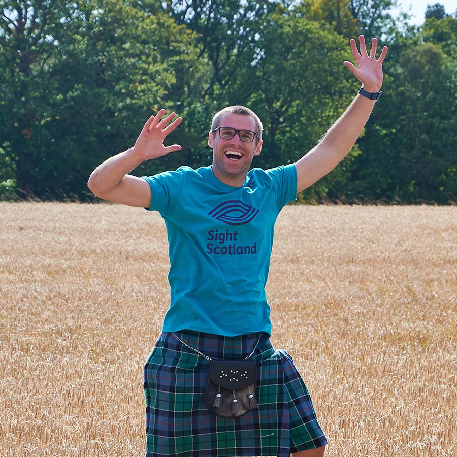 Sight Scotland workers in kilts jumping in field Sight Scotland workers in kilts jumping in field